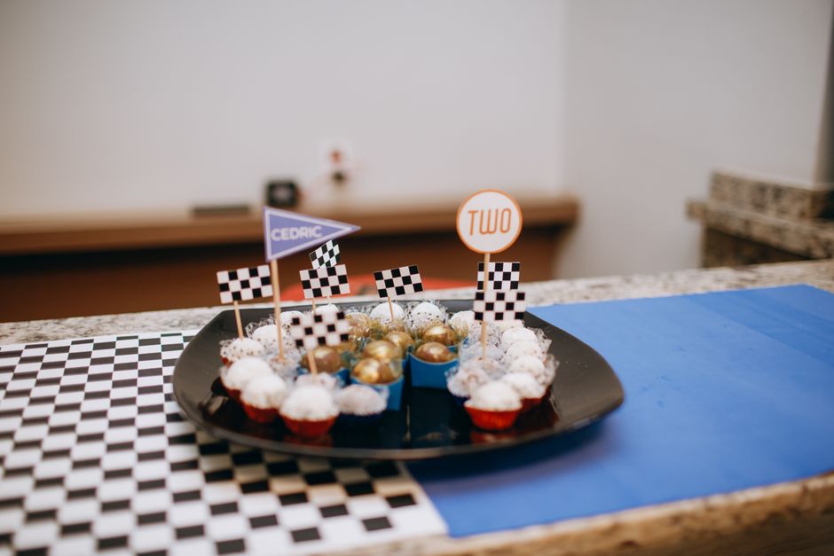 Balões decorativos e doces em uma mesa temática de corrida de carros, ideal para celebrações infantis ou eventos temáticos.