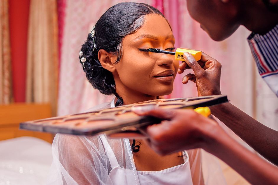 Mulher recebendo maquiagem profissional durante uma preparação para foto ou evento, com foco na beleza e cuidado pessoal.