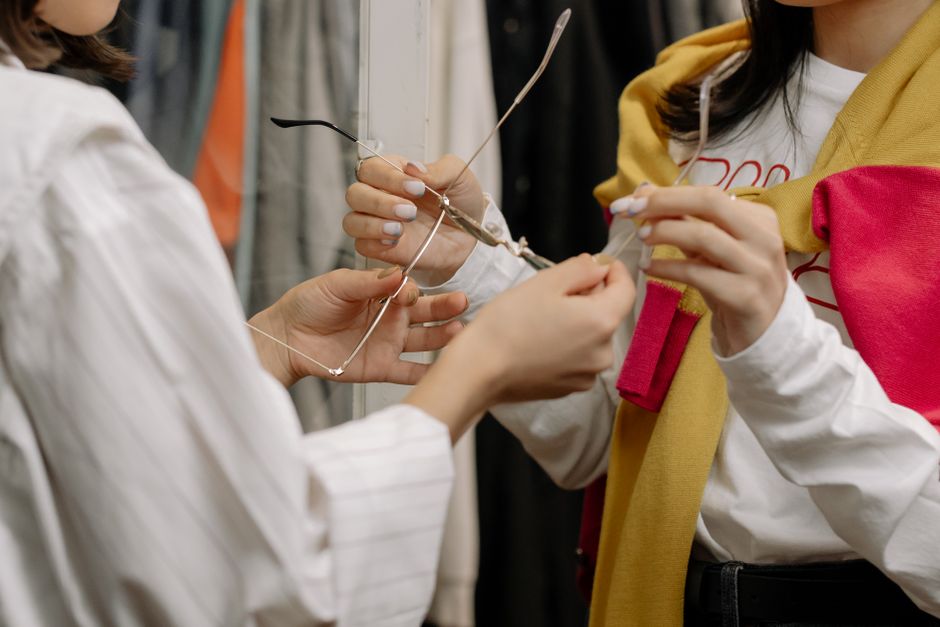Duas mulheres ajustando óculos de grau, simbolizando atenção aos detalhes e cuidado com a visão.