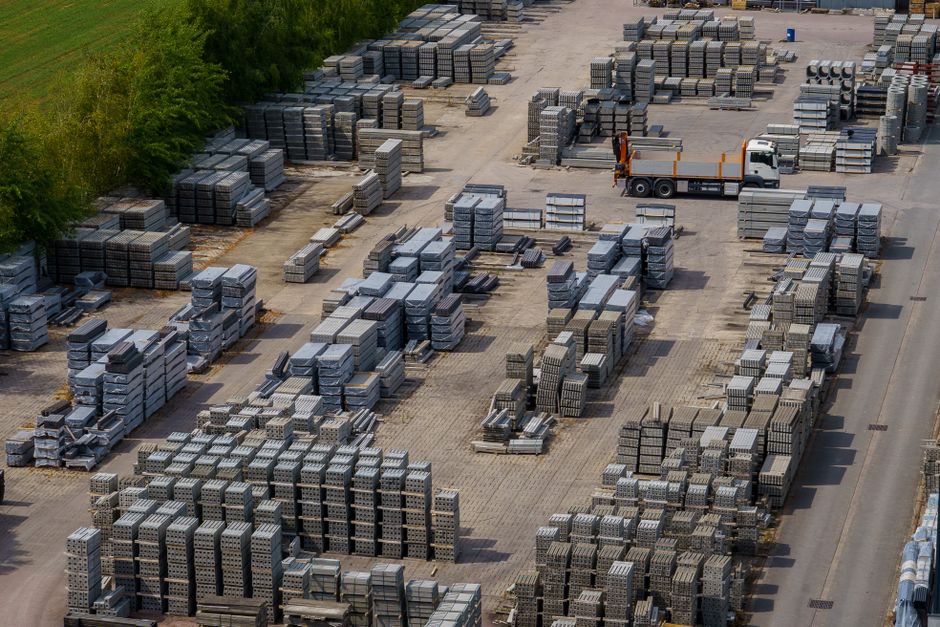 Imagem de um pátio de armazenamento de blocos de concreto, destacando a logística e gestão de materiais de construção.