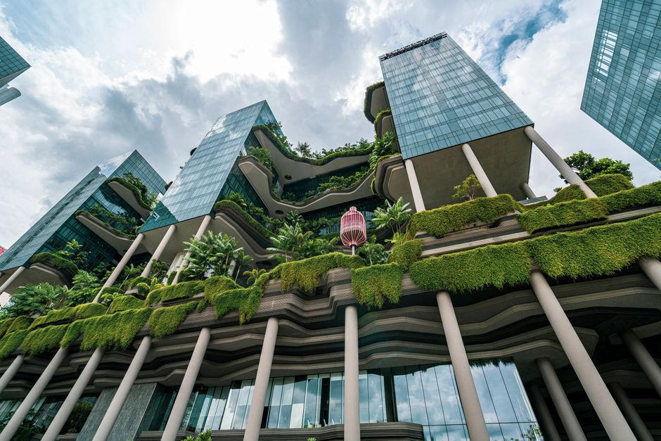 Vista de arranha-céu sustentável com jardins suspensos, destacando a integração entre arquitetura moderna e natureza.