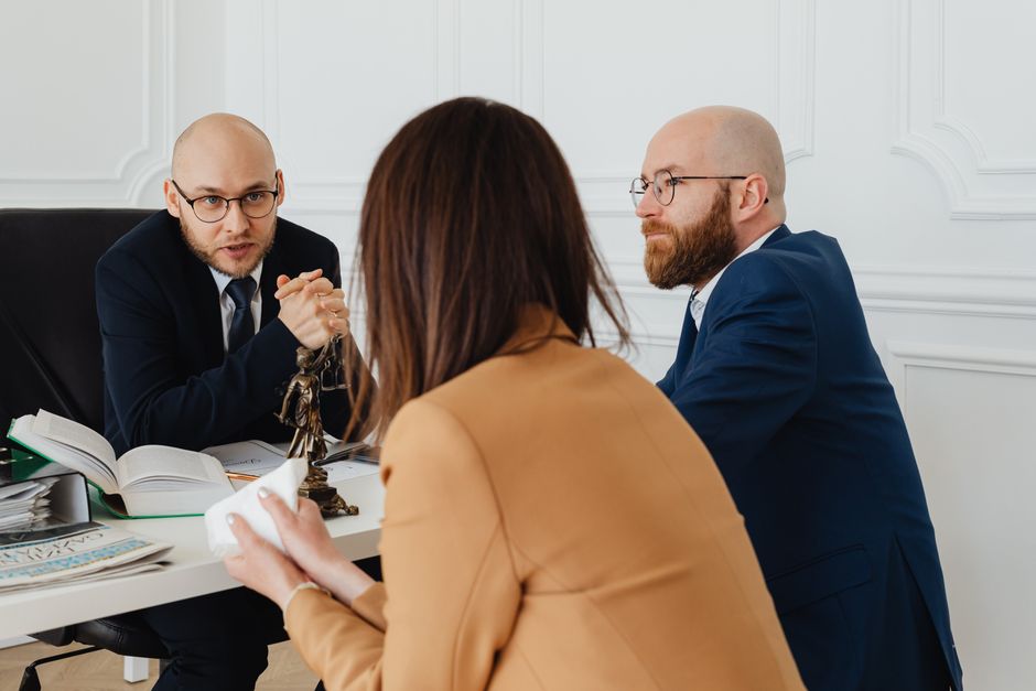 Reunião de profissionais em ambiente corporativo realizando uma discussão séria, possivelmente envolvendo decisão ou negociação empresarial.