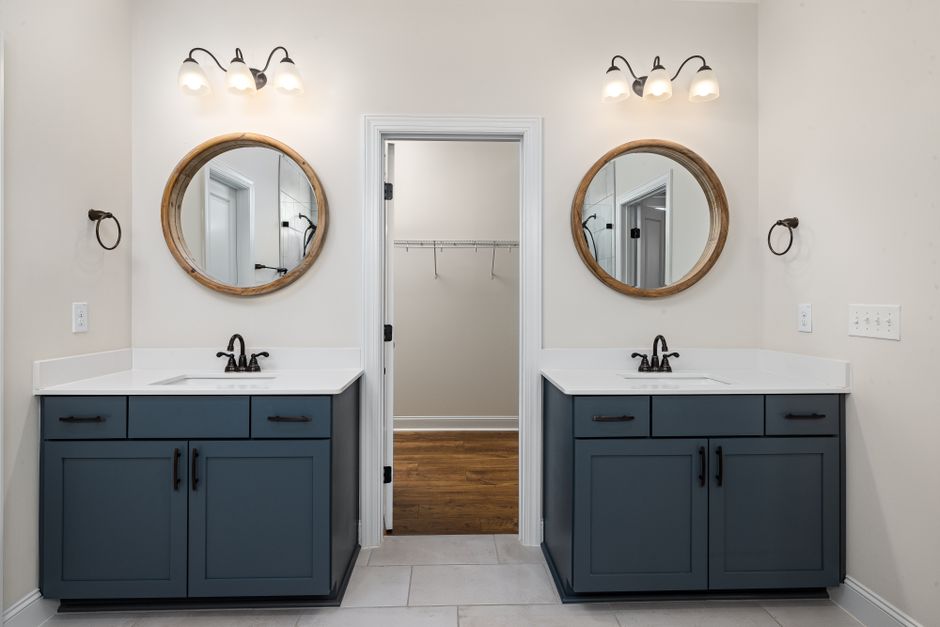 Imagem de um banheiro com decoração moderna, duplo espelho lateral e iluminação suave, ideal para artigos sobre design de interiores ou reformas.