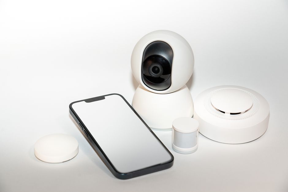 Imagem de dispositivos inteligentes de segurança conectados em uma superfície plana, destacando inovação tecnológica e automação residencial.