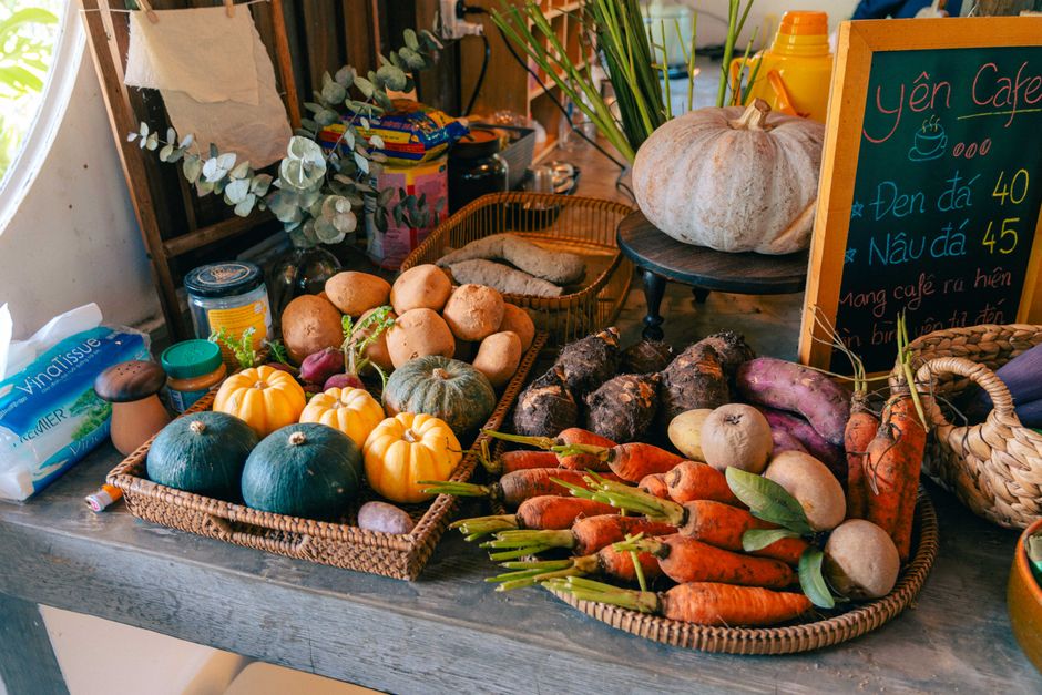 Exposição de legumes e hortaliças em uma feira, destacando a variedade de produtos naturais e frescos disponíveis para compras.