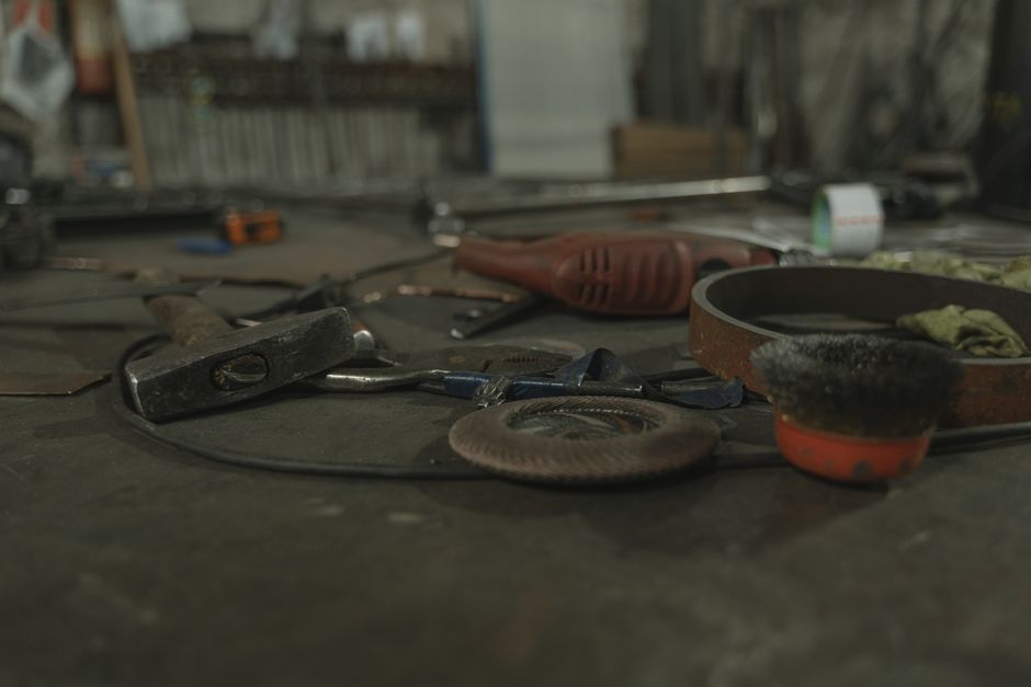 Imagem de uma bancada de oficina com ferramentas e equipamentos de manutenção ou fabricação artesanal.