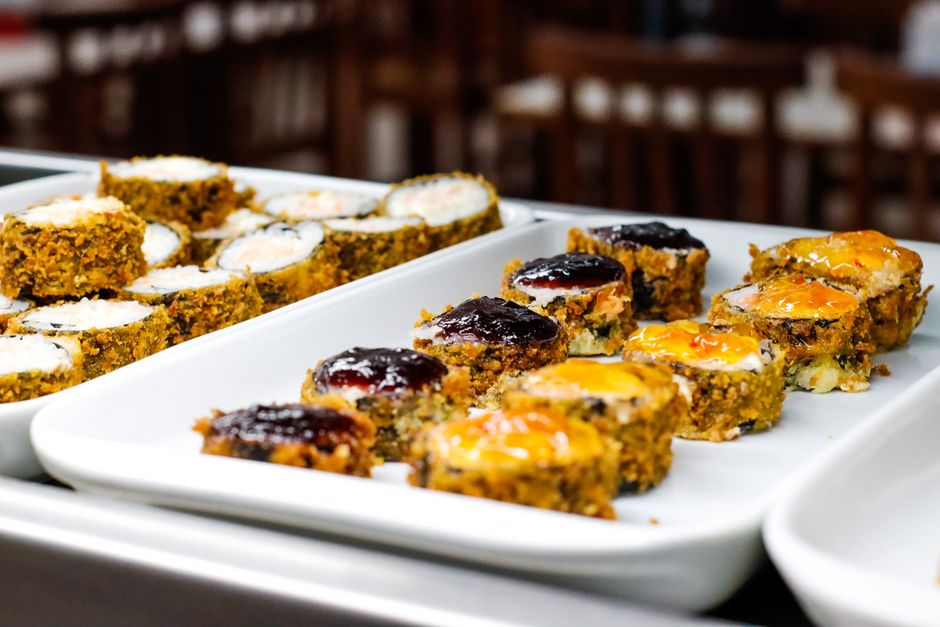 Imagem de uma variedade de pratos de comida em uma bandeja para servir em um buffet ou evento social.