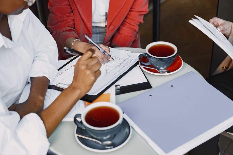 Reunião de negócios focada em planejamento financeiro e análise de estratégias, com participantes discutindo gráficos e documentos.