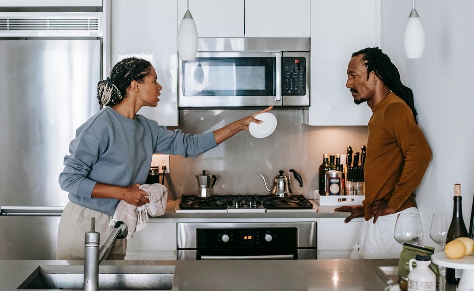 Casal discutindo de forma séria na cozinha, com ênfase na comunicação e relacionamento íntimo.