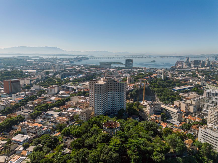 Vista aérea de uma cidade vibrante com áreas verdes, destacando o desenvolvimento urbano e a relação com o meio ambiente.