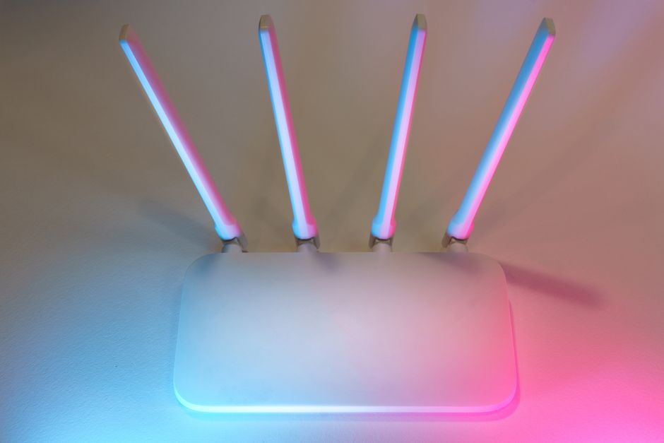 Imagem de um roteador com luzes coloridas, representando tecnologia e conectividade digital.