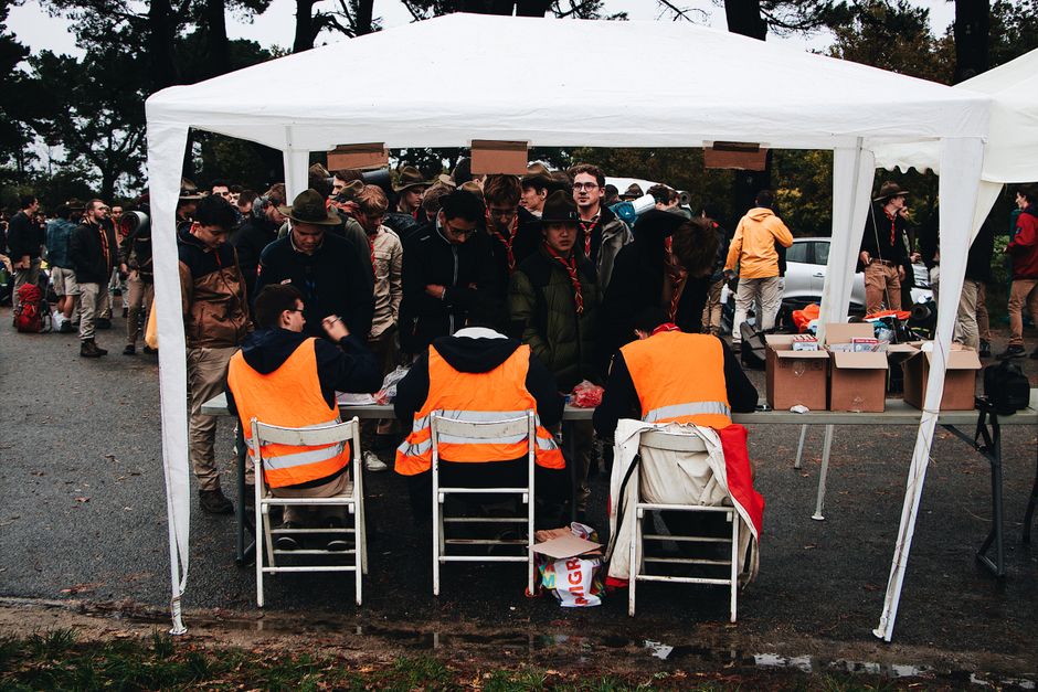 Grupo de jovens participando de um evento ao ar livre com organização e voluntariado.