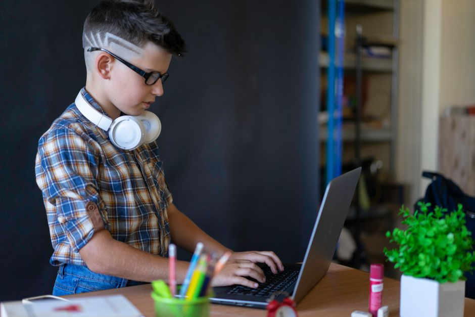 Juventude estudando ou trabalhando com laptops em um ambiente descontraído, indicando foco em tecnologia ou educação.