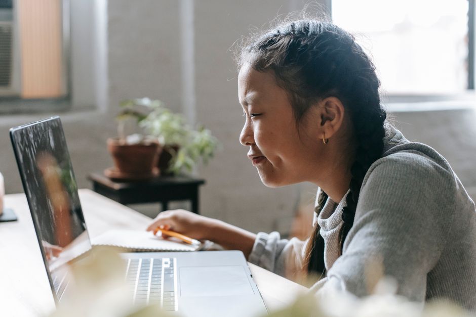 Mulher estudando ou participando de uma aula online em ambiente doméstico, demonstrando dedicação ao aprendizado digital.