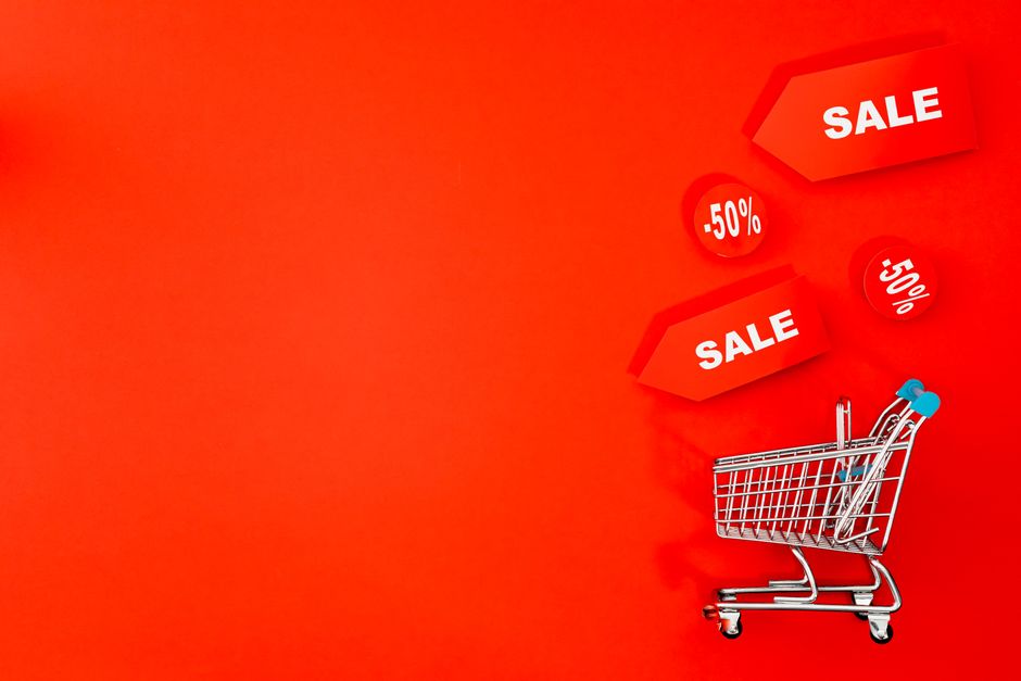 Carrinho de compras digital com etiquetas de promoção e descontos, representando estratégias de vendas e liquidações no comércio eletrônico.