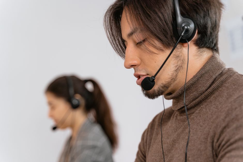 Dupla de atendentes de suporte ao cliente trabalhando em call center com foco em atendimento e comunicação eficiente.