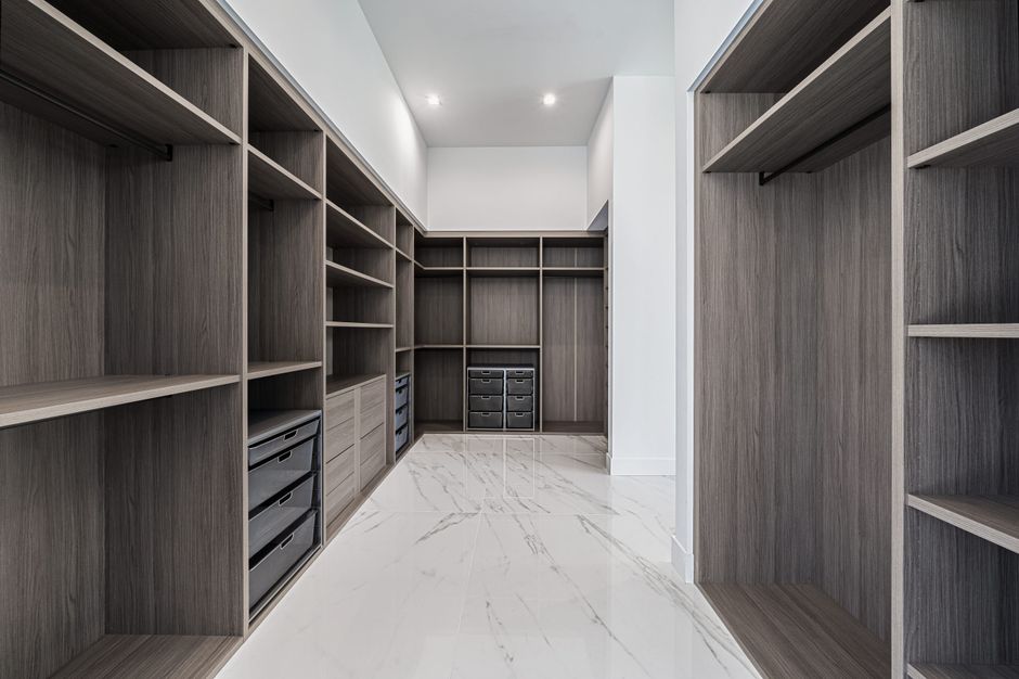 Imagem de um closet ou espaço de armazenamento organizado com prateleiras de madeira e gavetas modernas, perfeito para um blog de organização ou decoração de interiores.