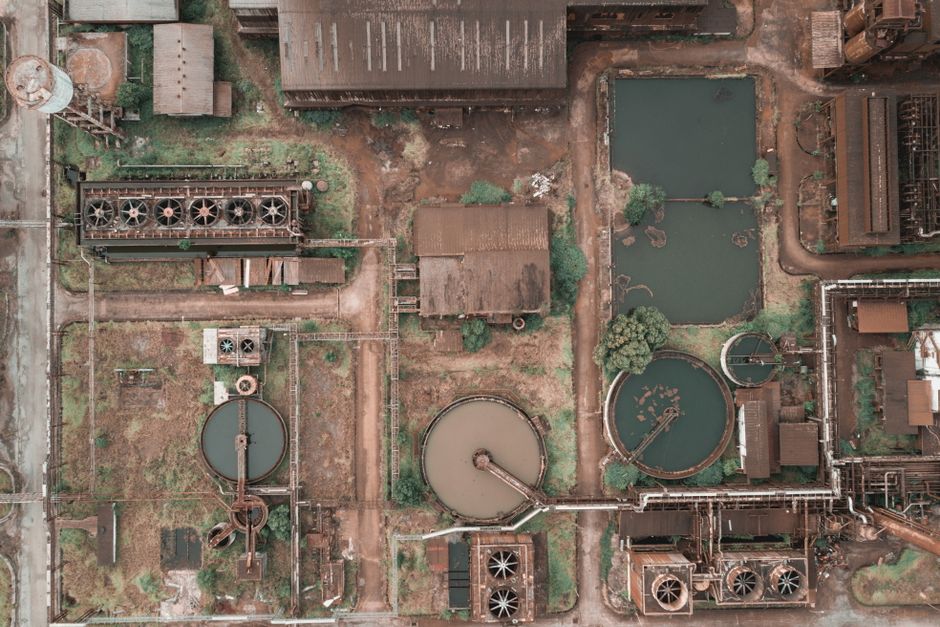 Visão aérea de uma usina de tratamento de água, destacando suas instalações de reservatórios, tanques e infraestrutura industrial.