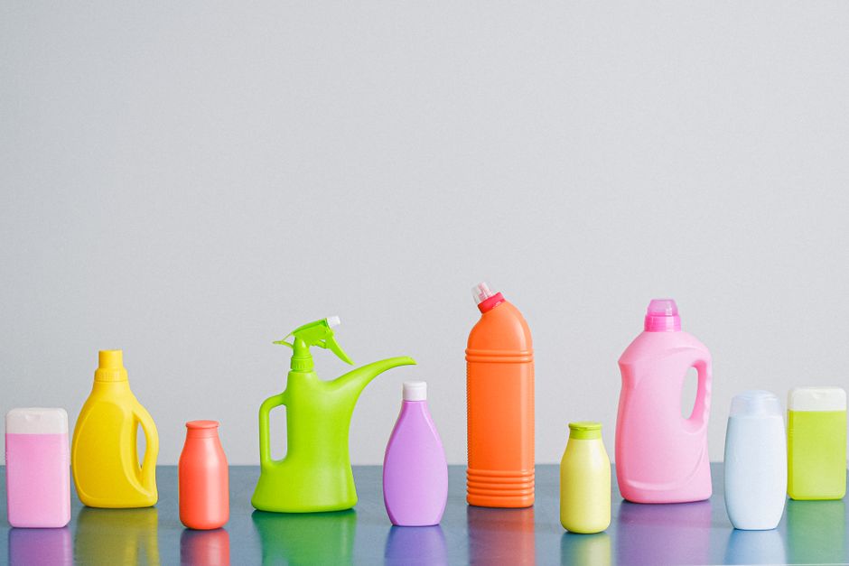 Imagem de diferentes garrafas e recipientes de produtos de limpeza coloridos, dispostos em linha como elemento visual para temas relacionados à higiene, produtos domésticos ou sustentabilidade.