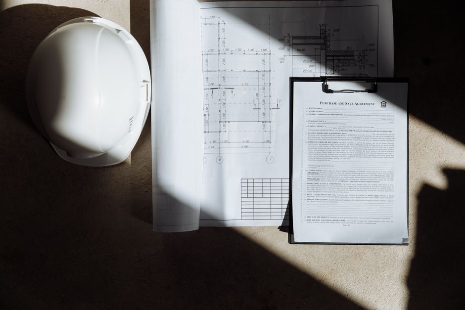 Planta de construção e documentos relacionados em um ambiente de projeto arquitetônico.