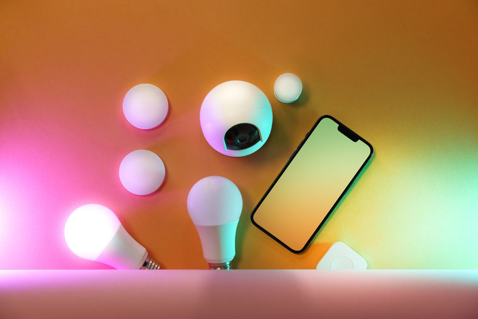 Imagem que destaca tecnologia e criatividade com luzes inteligentes, câmera de segurança e smartphone sobre fundo colorido.