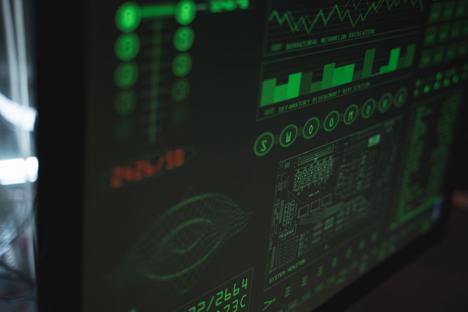 Imagem de um monitor com gráficos financeiros e dados de mercado, representando análise de investimentos ou mercado financeiro.
