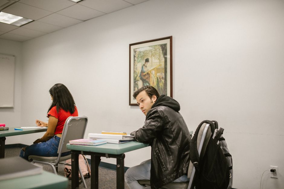 Estudantes em uma sala de aula ou sala de estudo, com foco em concentração e ambiente acadêmico.