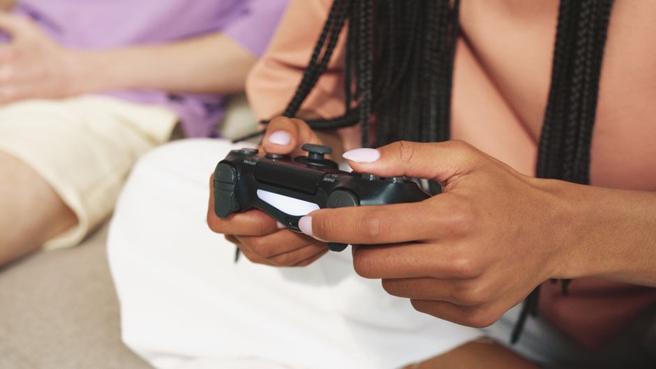 Pessoa jogando videogame com controle, destacando o tema do entretenimento digital e dos jogos eletrônicos.