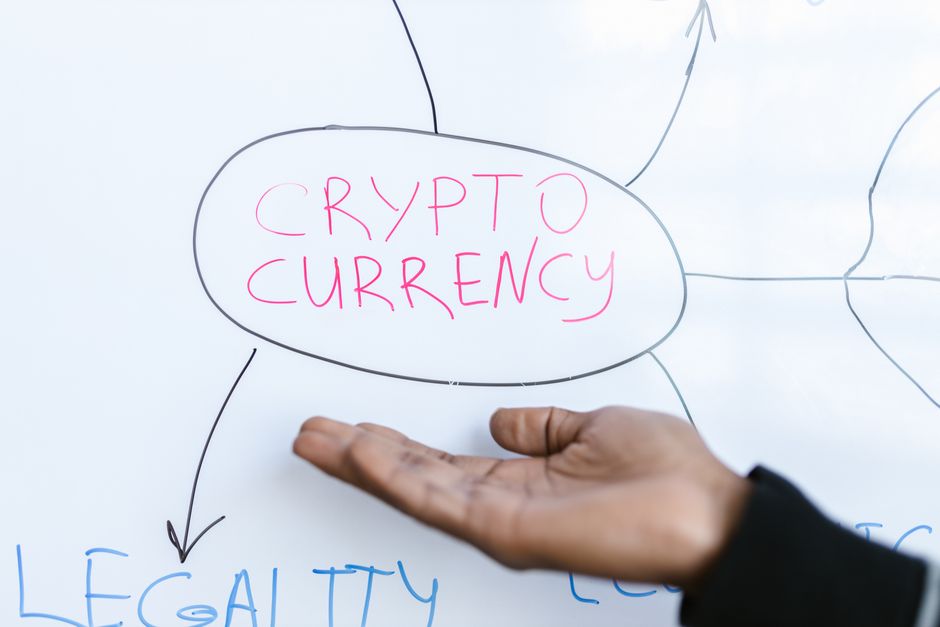 Imagem de uma pessoa apontando para uma nota visual com o termo 'Crypto Currency', relacionada a temas de investimentos em criptomoedas e inovação financeira.