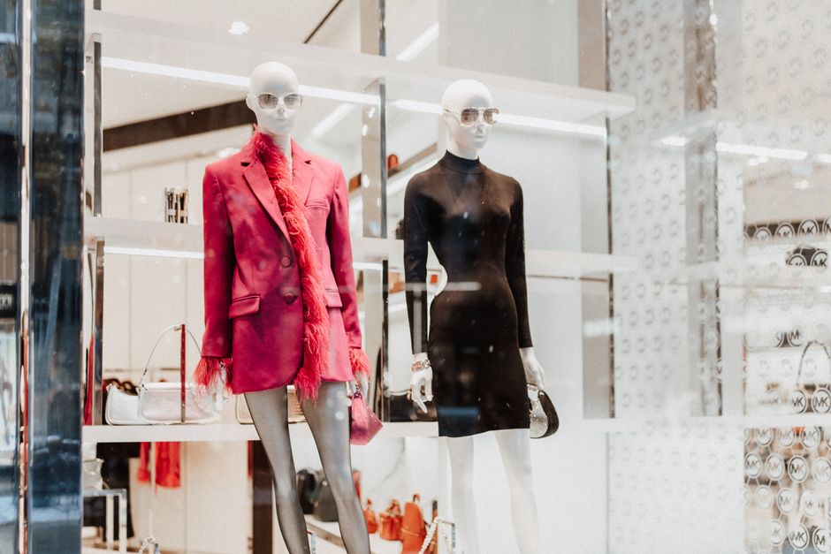Mostruário de moda exibindo roupas e acessórios sofisticados em uma loja de roupas de alto padrão.