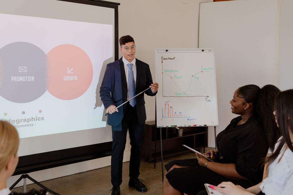 Homem apresentando estratégia de crescimento e promoção em uma sala de reunião com uma equipe durante um treinamento ou workshop de negócios.