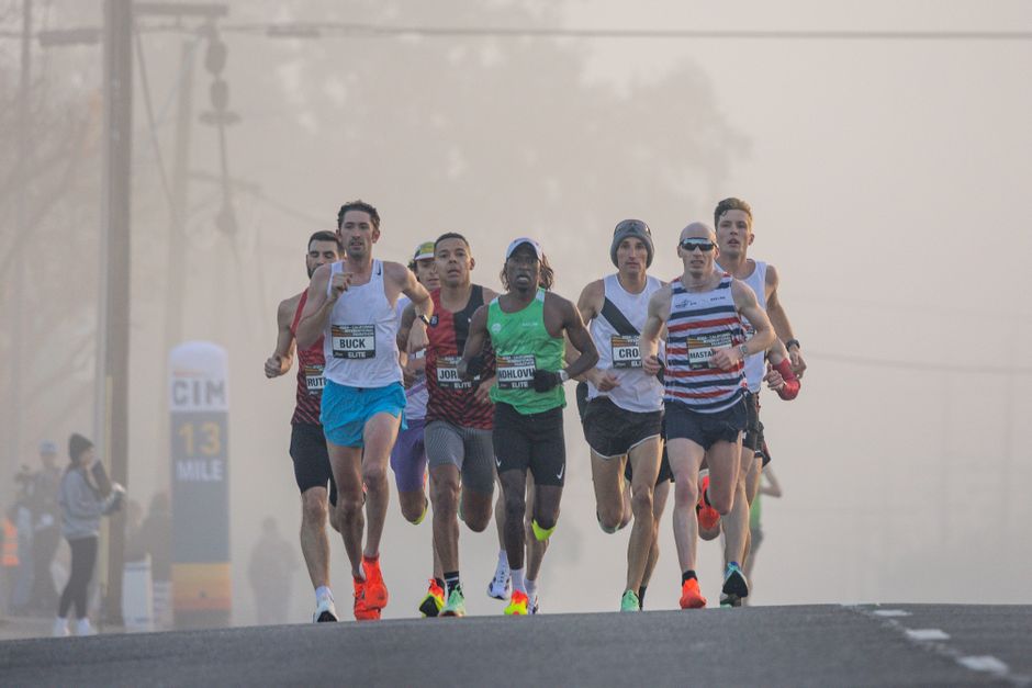 Grupo de corredores participando de uma maratona urbana ao amanhecer, representando esforço, resistência e espírito esportivo.