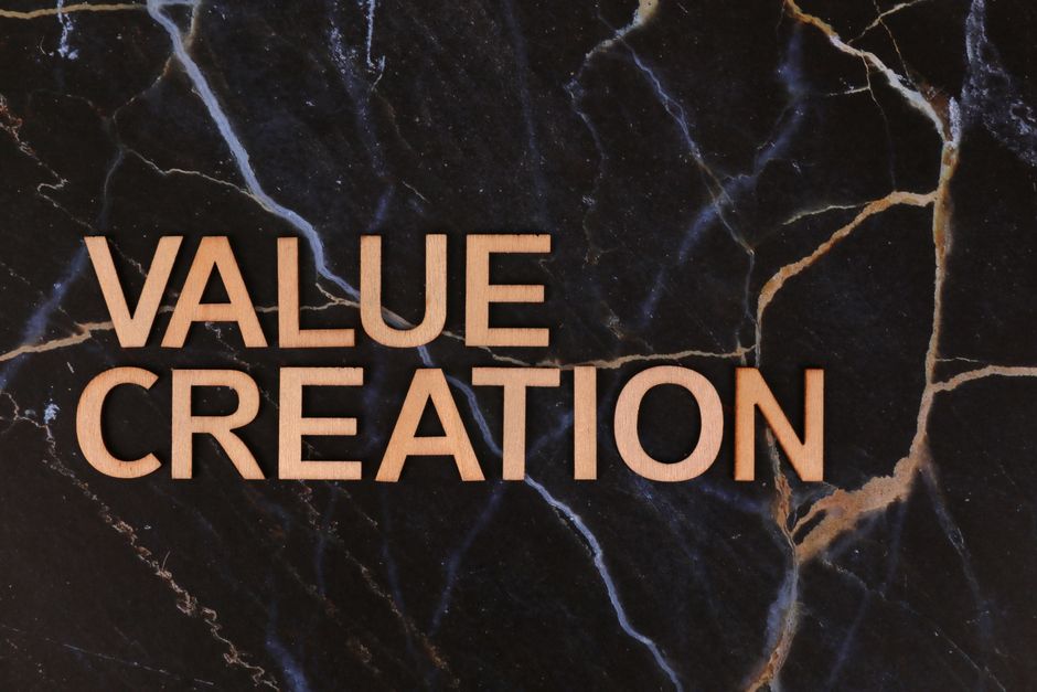Imagem com o texto 'Value Creation' em destaque, sobre fundo de mármore escuro, representando inovação e geração de valor em negócios.