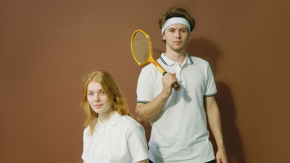 Jovens vestidos com roupas esportivas e acessórios de tênis, simbolizando um tema de esporte ou lazer ao ar livre.