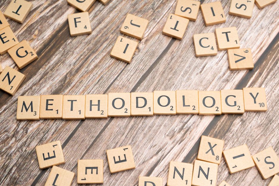 Imagem de blocos de palavras formando 'Metodologia', simbolizando organização e processos no contexto educacional ou de pesquisa.