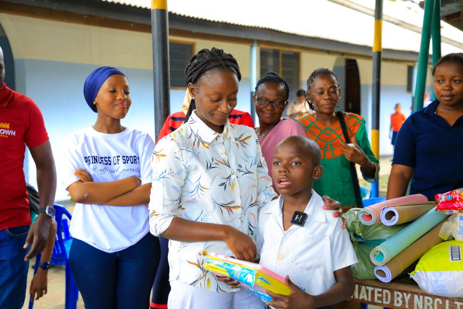 Grupo de mães e crianças participando de um programa de apoio social ao ar livre, promovendo inclusão e bem-estar comunitário.