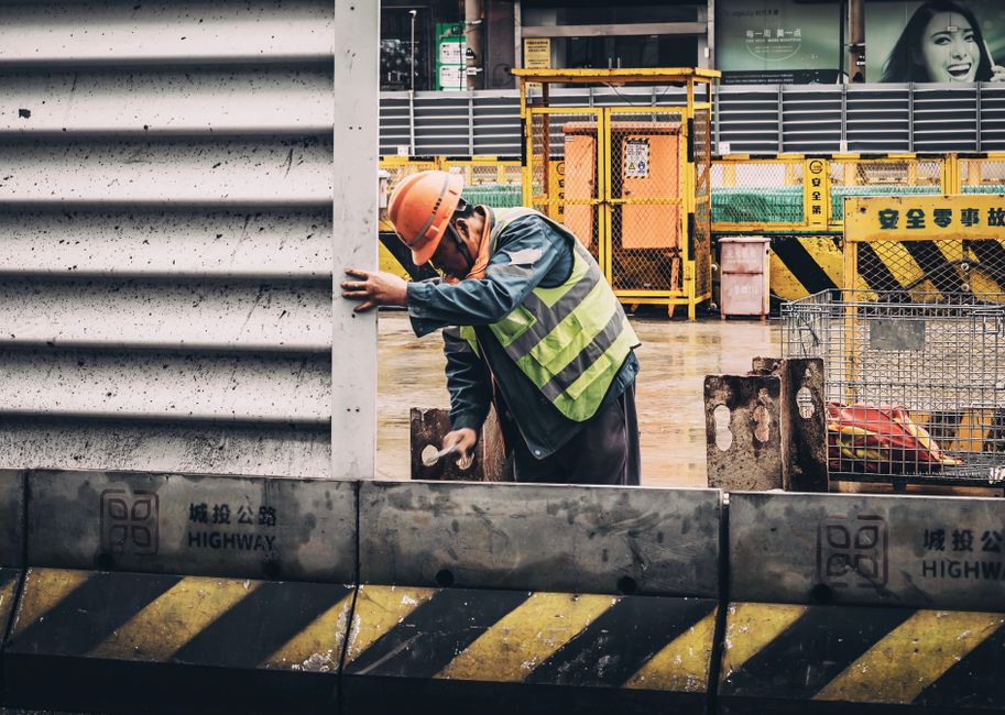 Homem trabalhando na construção civil, demonstrando esforço e foco na obra.