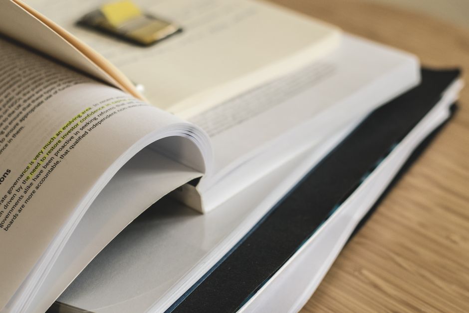 Imagem de livros abertos e em pedacinhos, representando estudo, leitura ou pesquisa acadêmica.