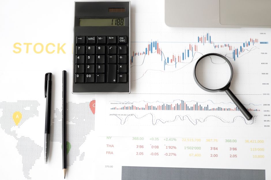Imagem relacionada à análise financeira e investimentos, com elementos como calculadora, gráficos de ações e lupa para destaque de dados.
