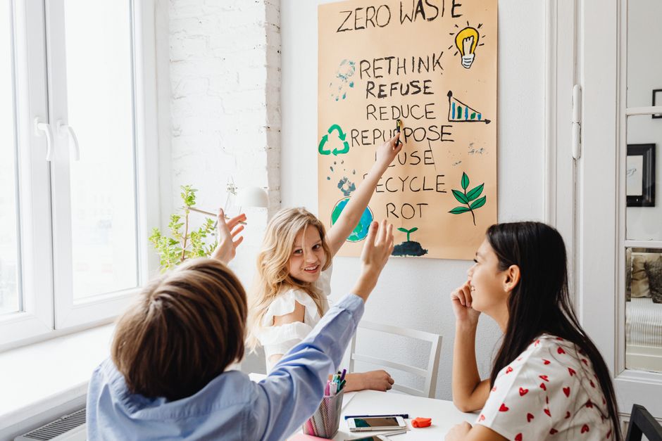 Grupo de pessoas discutindo práticas sustentáveis e estratégias para redução de desperdício e reciclagem em ambiente de escritório.
