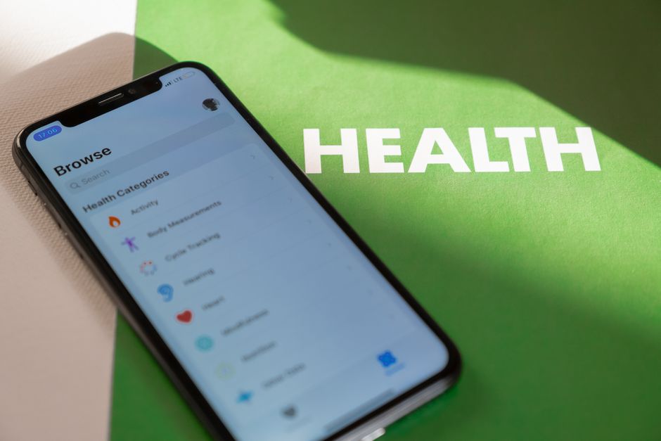 Imagem de um celular exibindo opções de saúde e bem-estar sobre um fundo com a palavra 'HEALTH', simbolizando o uso de tecnologia para cuidado com a saúde.