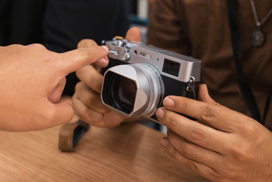 Pessoas ajustando uma câmera fotográfica, enfatizando o tema de fotografia e tecnologia.