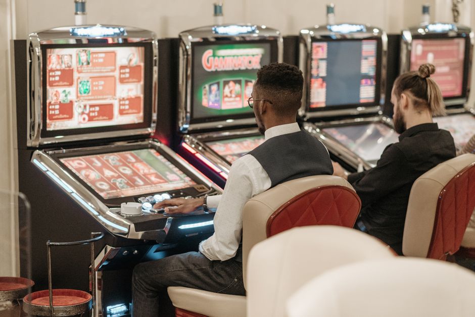 Homens jogando video game em ambiente de cassino, destacando entretenimento e jogos de azar.