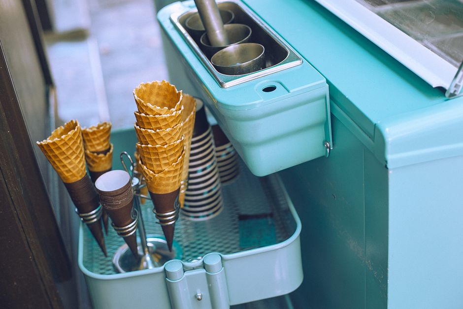 Imagem de uma máquina de sorvete com conchas de sorvete de waffle ao lado, ideal para ilustrar blog sobre sobremesas e vendas de sorvetes.