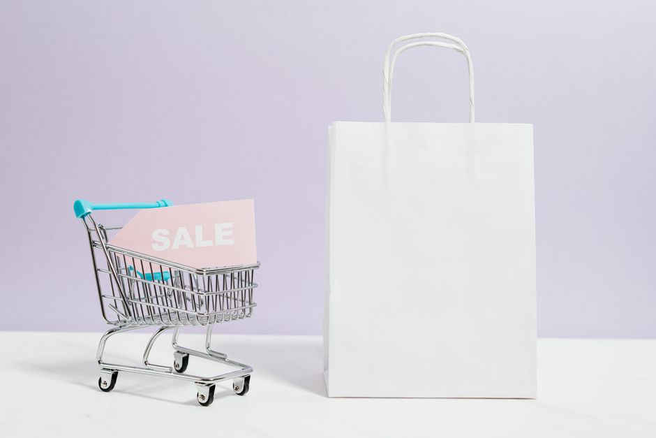 Imagem que representa compras online e promoções com uma sacola e um carrinho de compras contendo um aviso de 'SALE'.