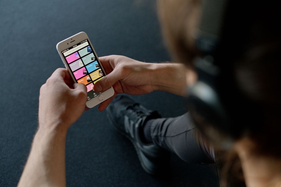 Pessoa utilizando smartphone para acessar aplicativos relacionados a produtividade ou negócios em um ambiente informal.