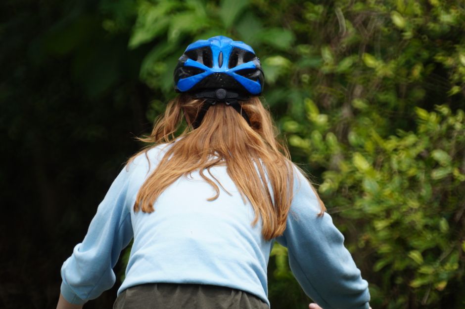 jovem praticando mountain bike em trilha natural com vegetação exuberante ao redor