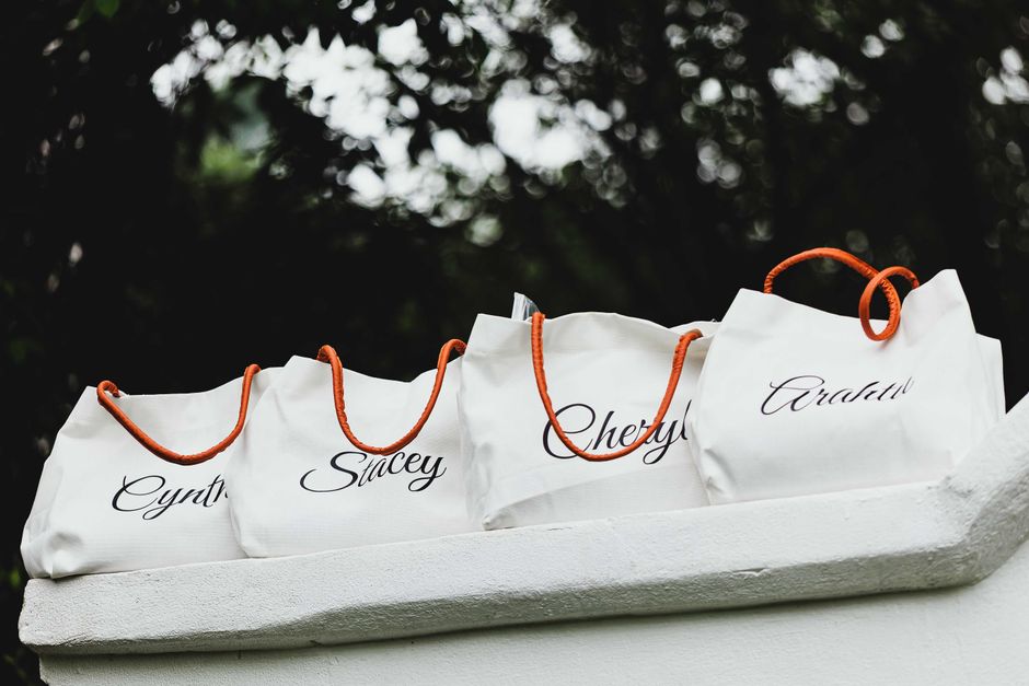 Imagem de sacolas de compras personalizadas com nomes, destacando o tema de presentes ou consumo para uso em blog sobre dicas de presentes e eventos especiais.