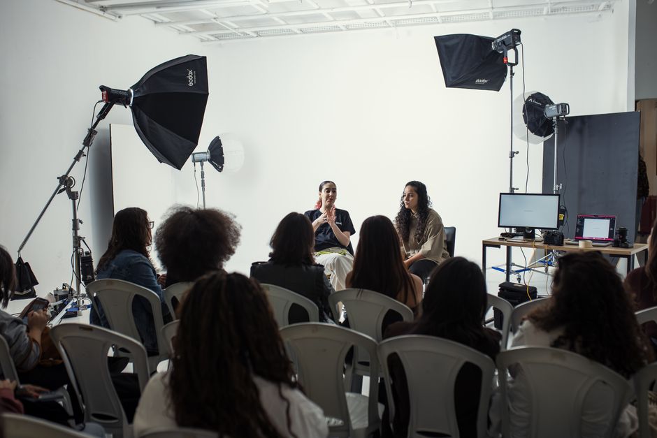 Imagem de uma entrevista ou debate em um estúdio de gravação, com painelistas e equipe de produção, focada em comunicação e conteúdo audiovisual.