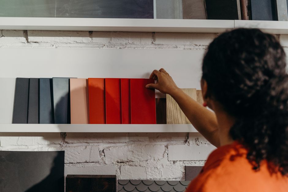 Pessoa escolhendo cores de materiais de design ou decoração em uma loja, cenários que representam tendências em estilos e acabamentos.